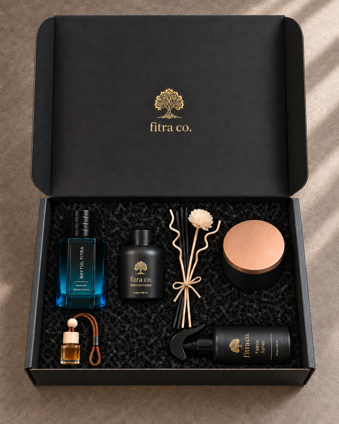 Five products in the open Fitra Premium Gift Set, with a full-length lid and ribbon-tied black reeds, curly reeds and cream flower beside the home diffuser.